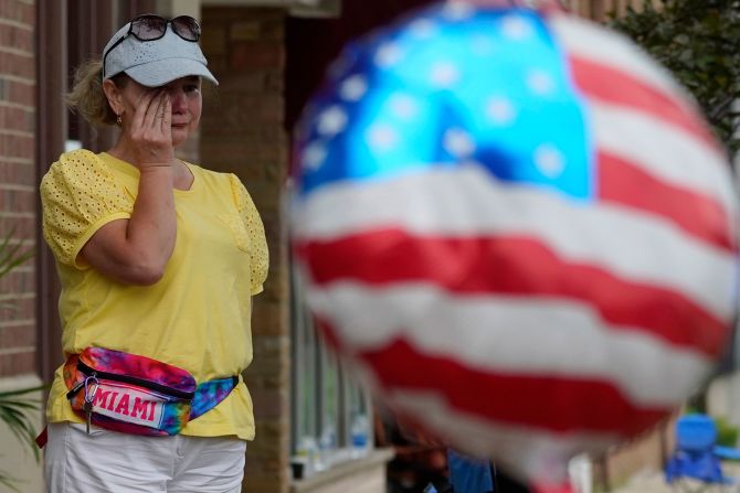 A woman wipes tears after a shooting at the Highland Park Fourth of July parade.
