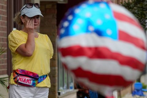 A woman wipes tears after a shooting at the Highland Park Fourth of July parade in Illinois. 