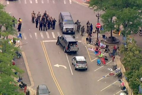 Police gather at the scene of the shooting in Highland Park, Illinois, on Monday. 