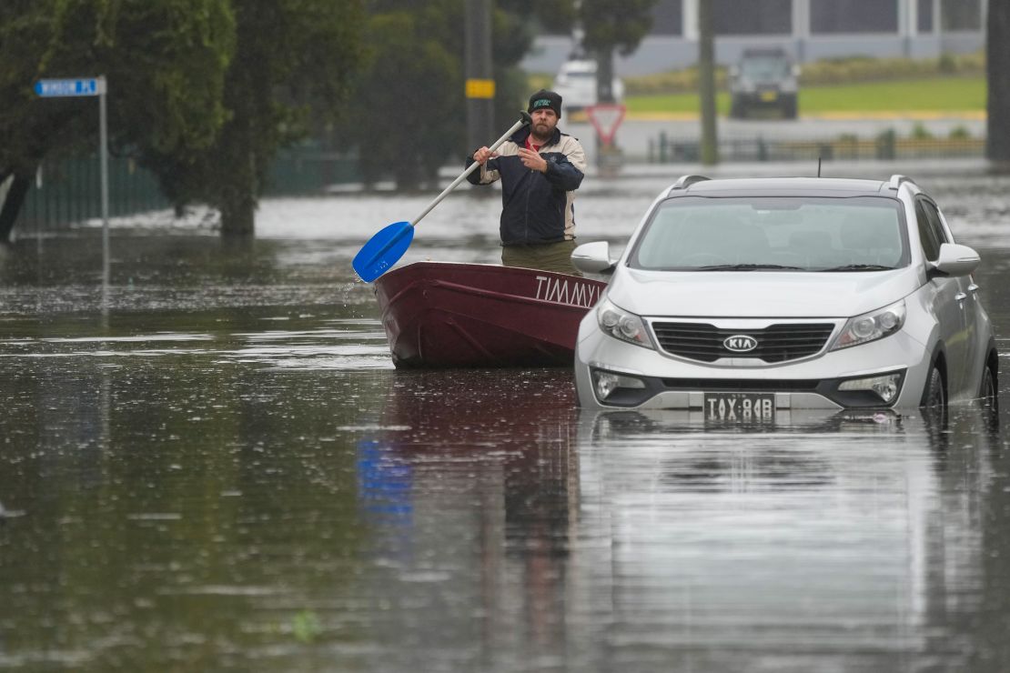 A man paddles his boat down a flooded street at Windsor on the outskirts of Sydney, Australia, July 5, 2022.