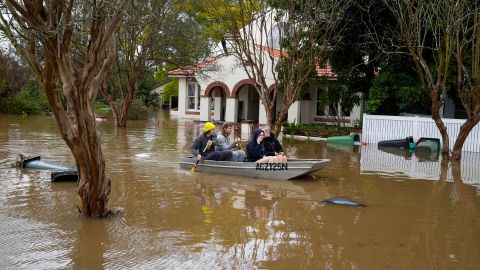 People paddle through a flooded street at Windsor, Australia, July 5, 2022