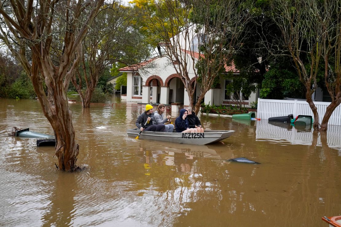People paddle through a flooded street at Windsor, Australia, July 5, 2022