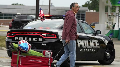 A man carries his belongings after a mass shooting at the Highland Park Fourth of July parade in downtown Highland Park, Ill., a Chicago suburb on Monday, July 4, 2022. (AP Photo/Nam Y. Huh)