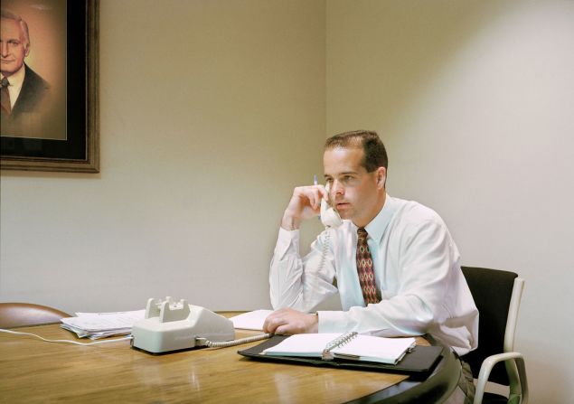 A man using a landline phone at an accounting firm.