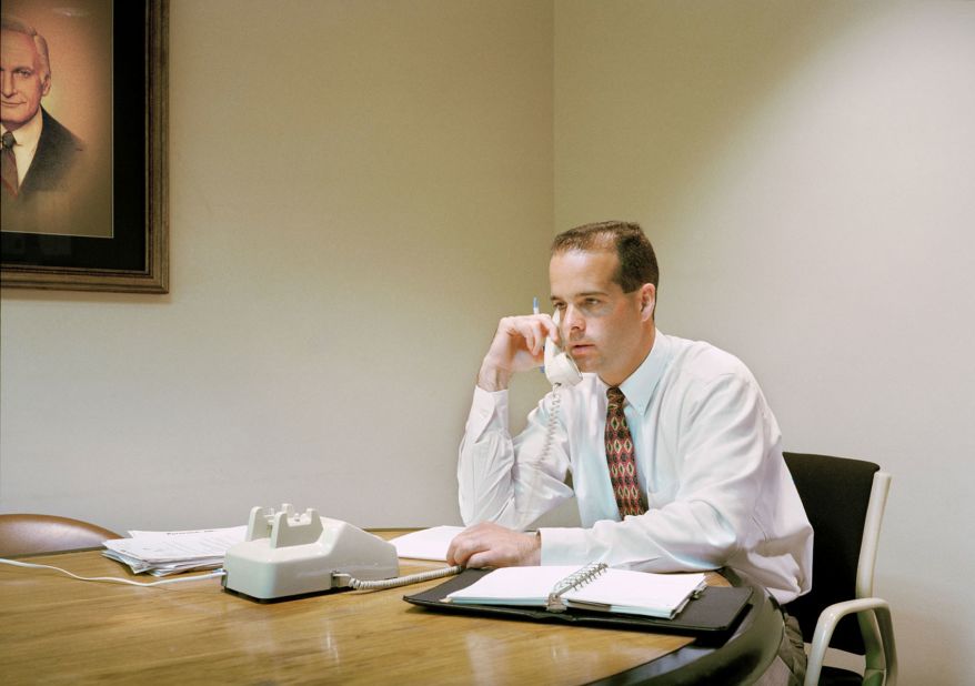 A man using a landline phone at an accounting firm.