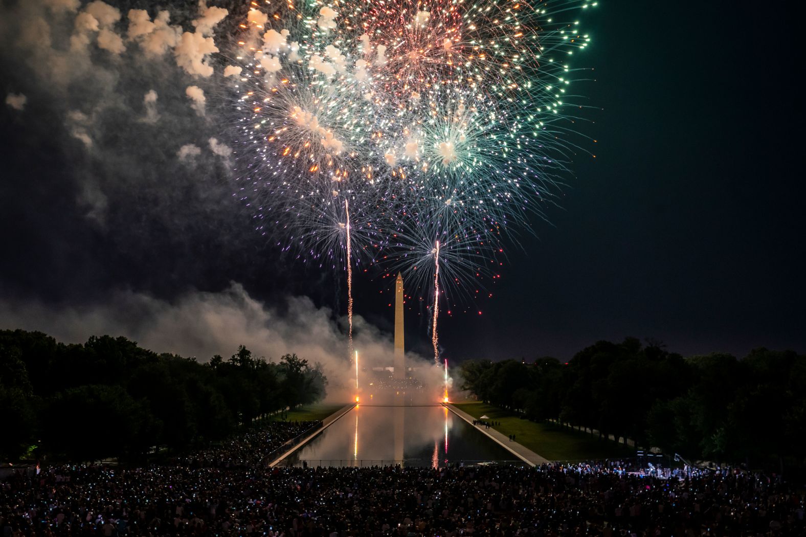 Spectators watch fireworks erupt over the Washington Monument Monday.