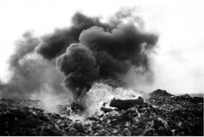Macilau initially shot in color, but says he prefers to develop his photos in black and white. "Color used to steal what is the intention behind my work," he says, while the black and white images are "more poetic." Pictured: "Tyres on Fire," The Profit Corner Series (2015).