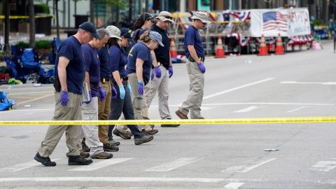 Members of the FBI's evidence response team walk the scene one day after a mass shooting in downtown Highland Park, Illinois, on Tuesday.