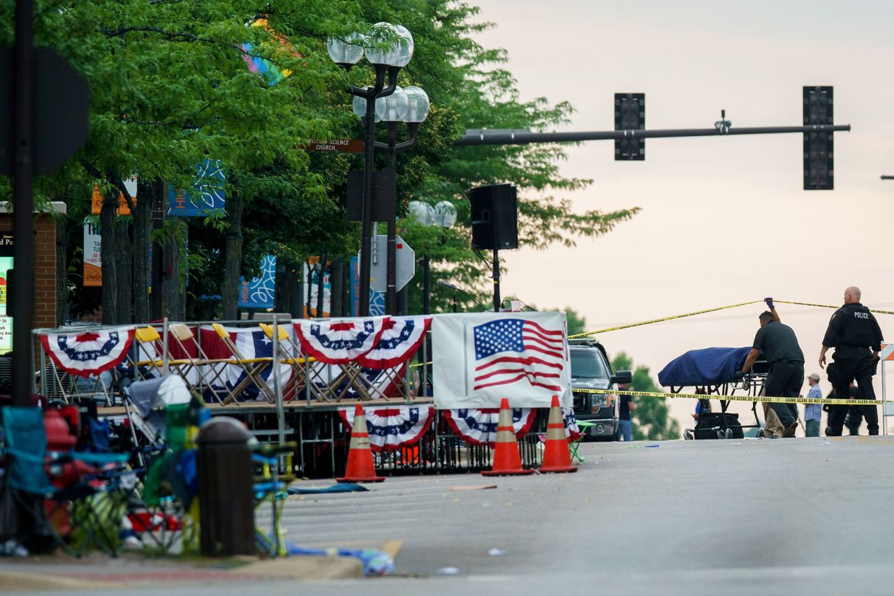 A body is transported from the scene of the shooting on July 4. 