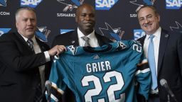 Mike Grier, middle, poses for photos as he is introduced as the new general manager of the San Jose Sharks between assistant general manager Joe Will, left, and president Jonathan Becher at a news conference in San Jose, Calif., Tuesday, July 5, 2022. (AP Photo/Jeff Chiu)