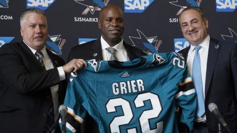 Mike Grier, middle, poses for photos as he is introduced as the new general manager of the San Jose Sharks between assistant general manager Joe Will, left, and president Jonathan Becher at a news conference in San Jose, Calif., Tuesday, July 5, 2022.