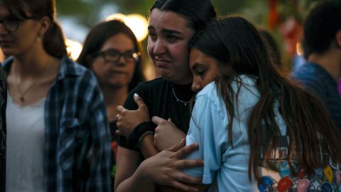 Mourners embrace during a memorial for the victims of the July 4th parade shooting on July 5, 2022 in Highland Park, Ill. 