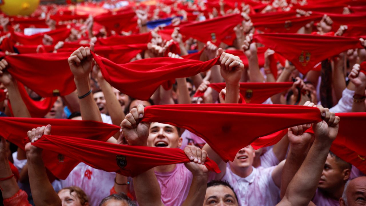 Revelers hold up traditional red scarves during the opening of the San Fermin festival in Pamplona, Spain on July 6, 2022. 