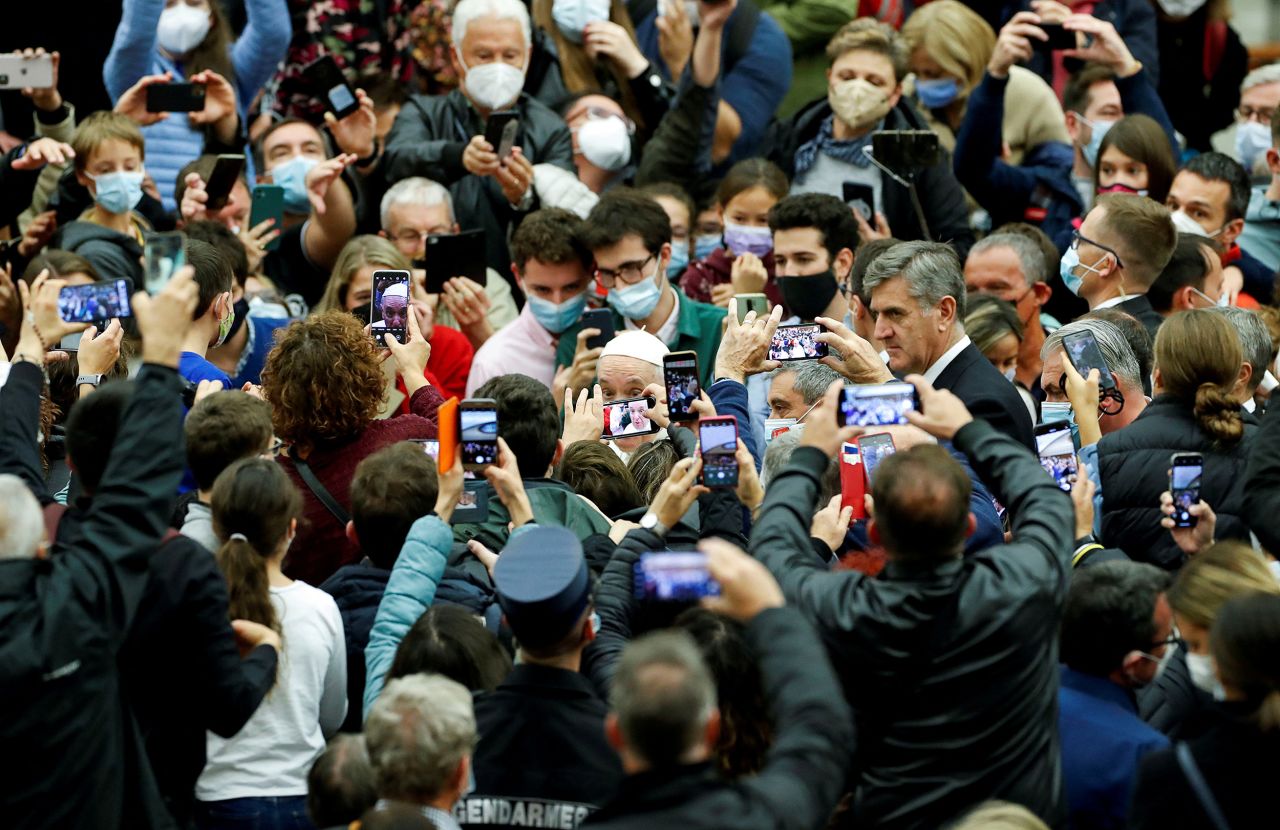 People take pictures of Pope Francis at the Vatican in November 2021.