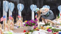 Highland Park resident Emily Mace places flowers at the memorials for the 7 killed in the 4th of July shooting in Highland Park Illinois. Mace was at the parade with her children, which they attend every year. She and her family were unharmed. Wednesday, July 6, 2022. 