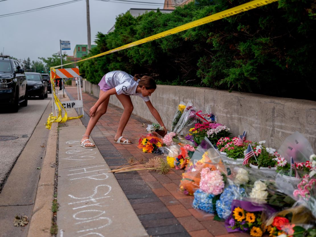 A mourner visits a memorial for the victims of a mass shooting in Highland Park. 