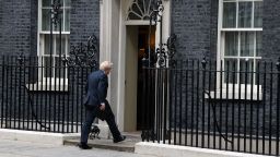 Britain's Prime Minister Boris Johnson walks back into 10 Downing Street in central London on July 7, 2022 after making a statement. - Johnson quit as Conservative party leader, after three tumultuous years in charge marked by Brexit, Covid and mounting scandals.