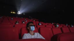 BEIJING, CHINA - JULY 24: People wear protective masks as they watch a movie in 3D at a theatre on the first day they were permitted to open on July 24, 2020 in Beijing, China. Cinemas in China's capital city re-opened after being closed for six months due to the COVID-19 pandemic on Friday. Under strict local health regulations cinemas are now allowed to sell tickets at 30 percent capacity, must adhere to social distancing measures, and all moviegoers must undergo a temperature check and show their local health code app in order to enter. (Photo by Kevin Frayer/Getty Images)