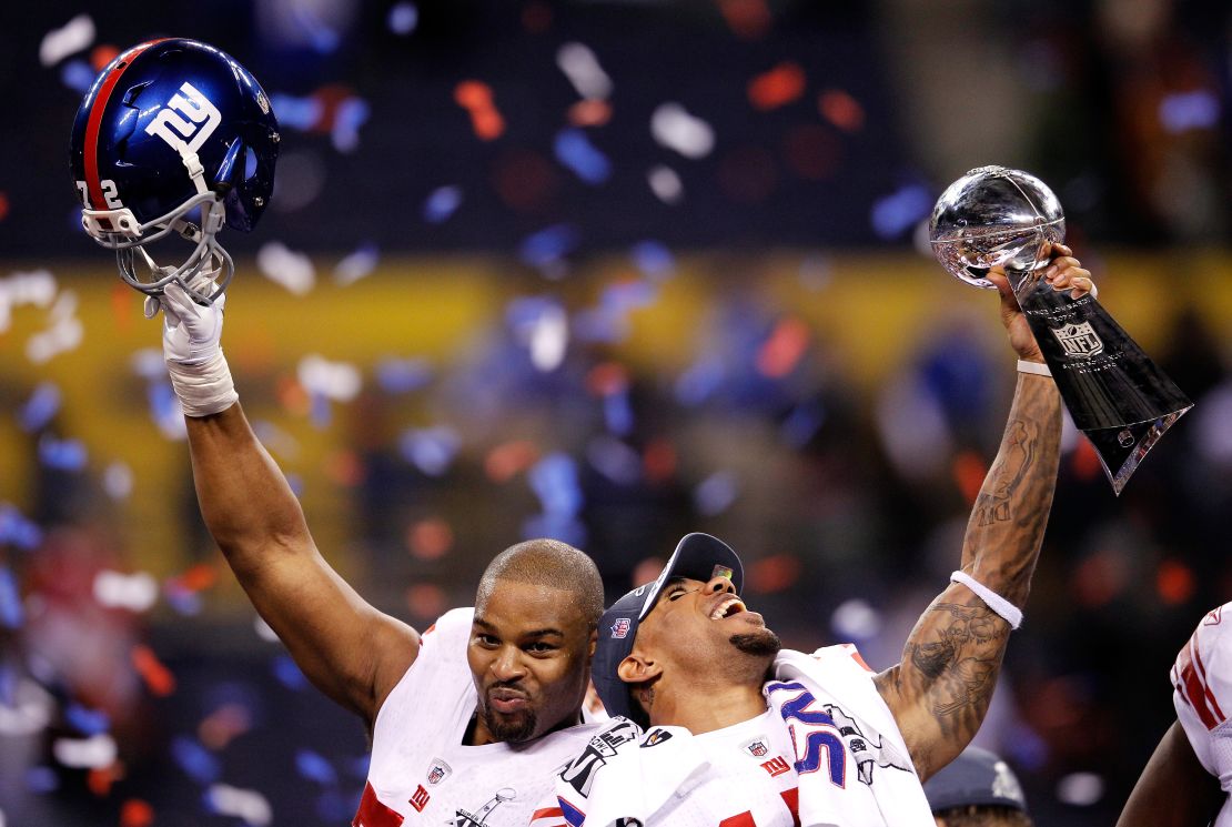 INDIANAPOLIS, IN - FEBRUARY 05: (LR) Osi Umenyiora #72 and Devin Thomas #15 of the New York Giants celebrate with the Vince Lombardi Trophy after the Giants' 21-17 win against the New England Patriots during Super Bowl XLVI at Lucas Oil Stadium on February 5, 2012 in Indianapolis, Indiana.  (Photo by Rob Carr/Getty Images)