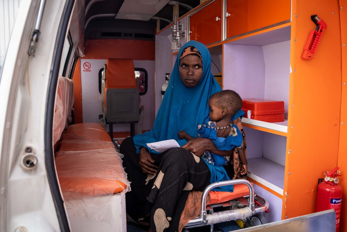 Ijabu Hassan sits in an ambulance waiting for help she could not get at home.