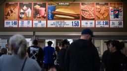 Customers wait in line to order below signage for the Costco Kirkland Signature $1.50 hot dog and soda combo, which has maintained the same price since 1985 despite consumer price increases and inflation, at the food court outside a Costco Wholesale Corp. store on June 14, 2022 in Hawthorne, California. 