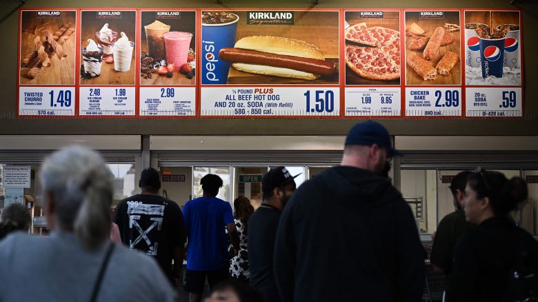 Customers wait in line to order below signage for the Costco Kirkland Signature $1.50 hot dog and soda combo, which has maintained the same price since 1985 despite consumer price increases and inflation, at the food court outside a Costco Wholesale Corp. store on June 14, 2022 in Hawthorne, California.