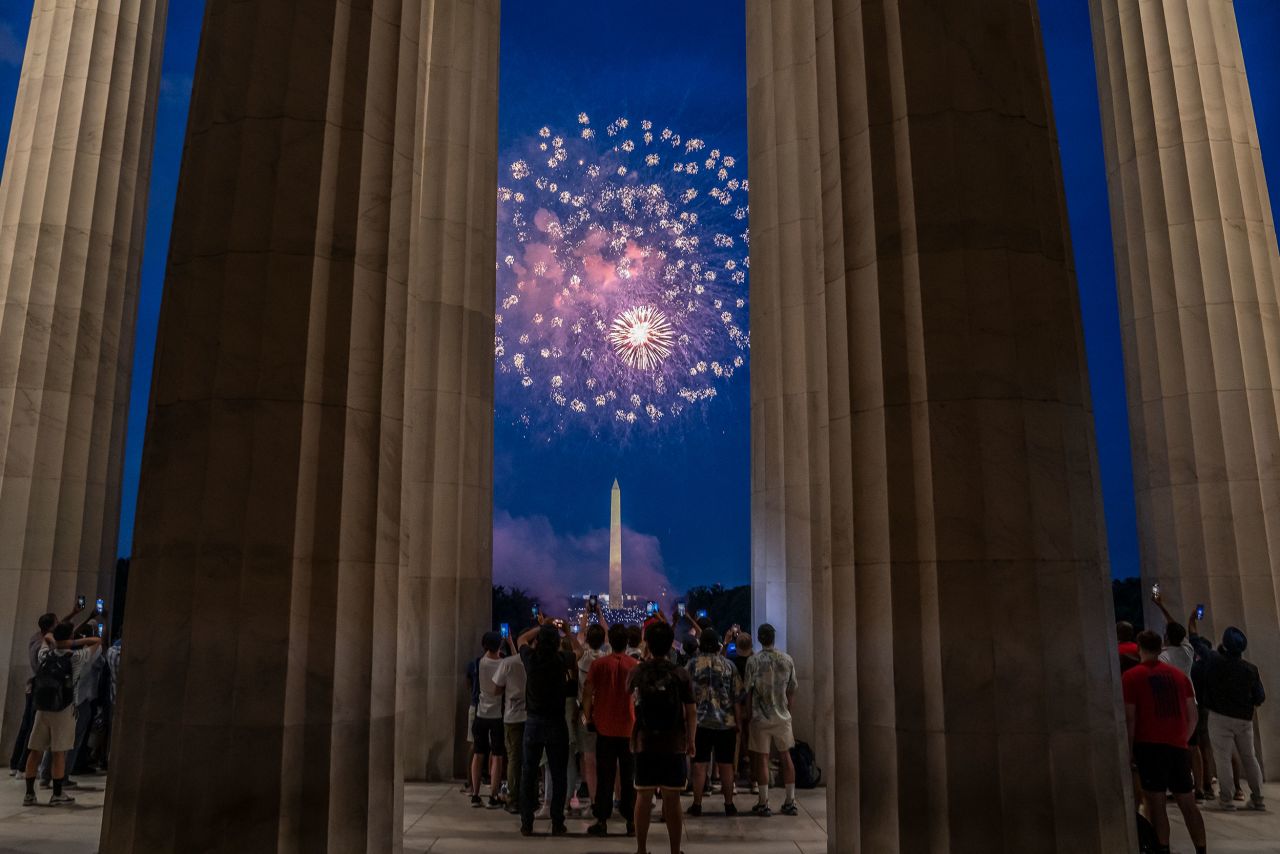 Spectators watch Fourth of July fireworks explode over the Washington Monument on Monday. Crowds lined the National Mall to watch the capital's annual fireworks show.