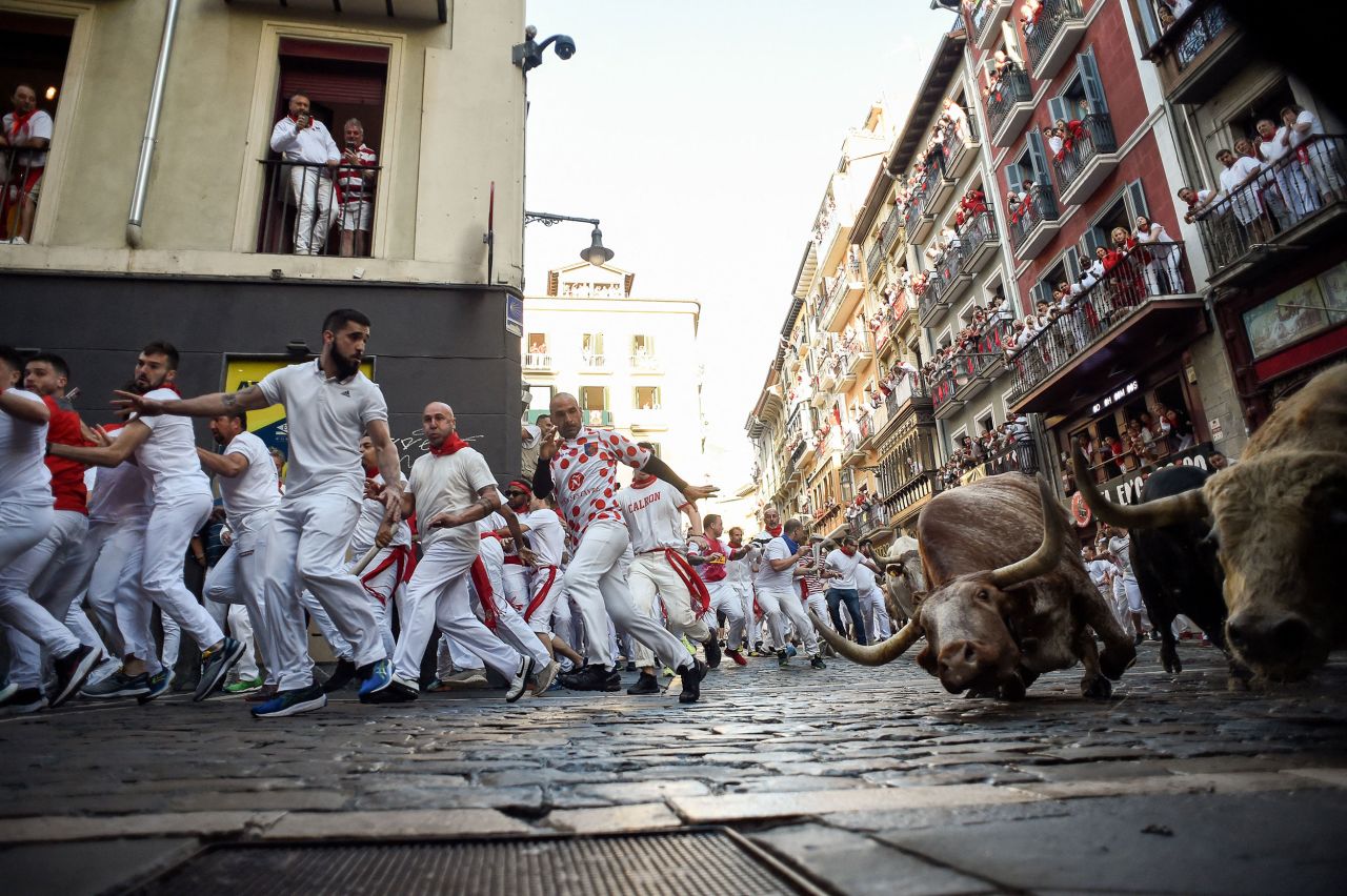 People try to avoid the bulls during the <a href="https://www.cnn.com/travel/article/six-injured-as-controversial-bull-run-returns-to-spains-pamplona/index.html" target="_blank">annual "running of the bulls"</a> in Pamplona, Spain, on Thursday, July 7. The San Fermin festival was canceled in 2020 and 2021 because of the Covid-19 pandemic.