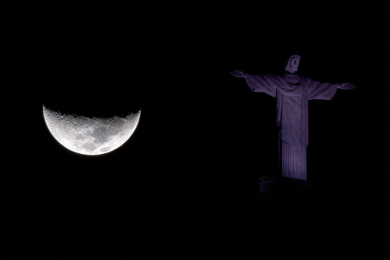The moon is seen behind the Christ the Redeemer statue in Rio de Janeiro on Tuesday, July 5.