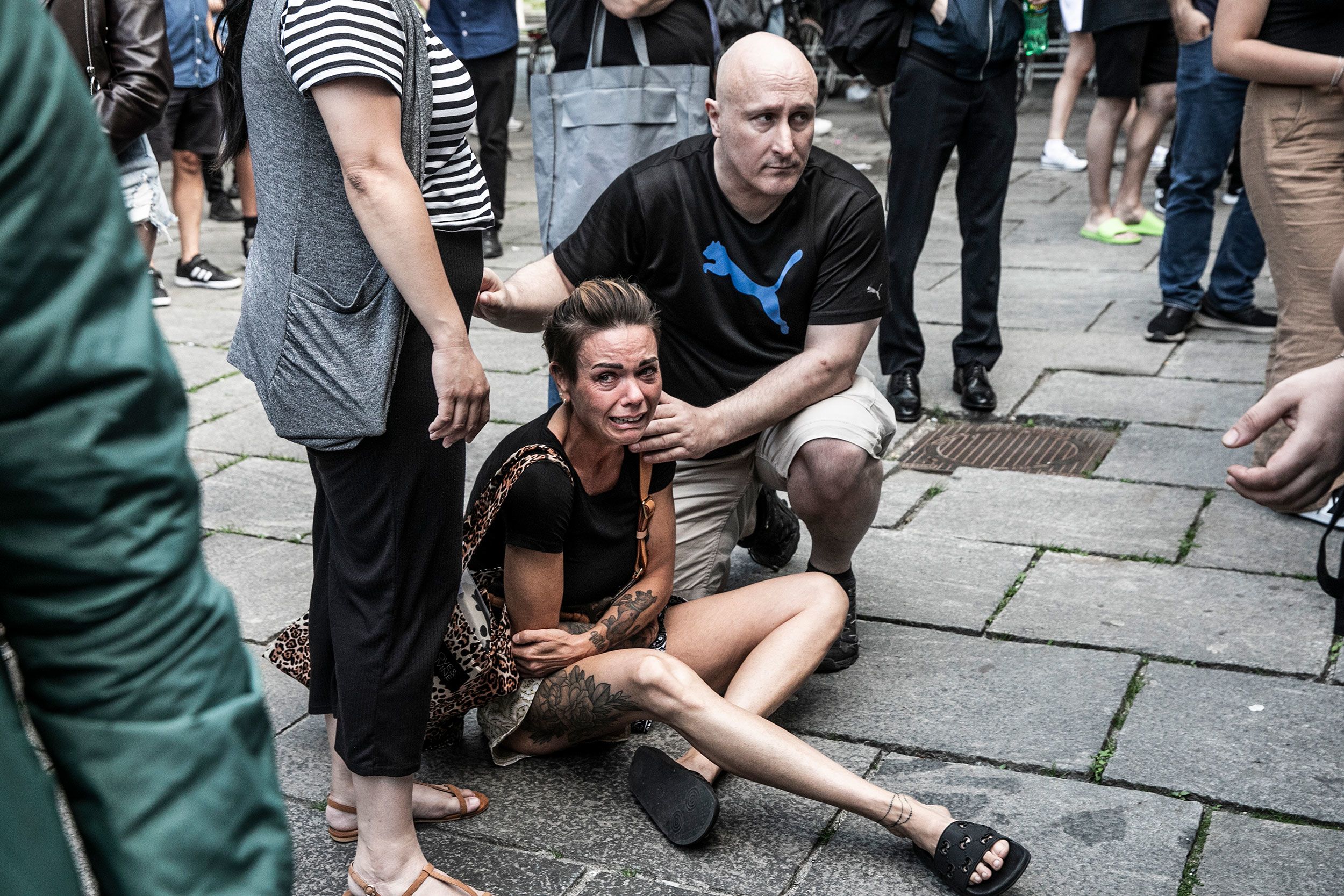 People help a woman in front of the Field's shopping center in Copenhagen, Denmark, after a gunman opened fire there on Sunday, July 3.