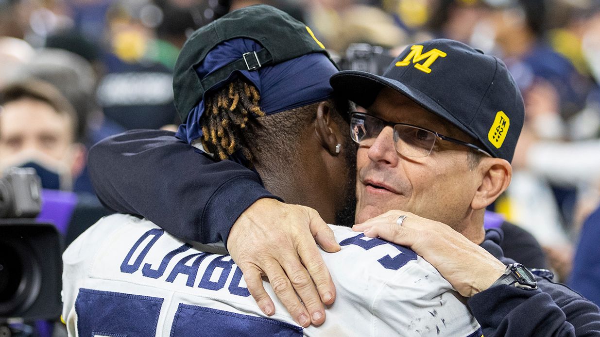 Ojabo and Michigan head coach Jim Harbaugh embrace after a game against the Iowa Hawkeyes.
