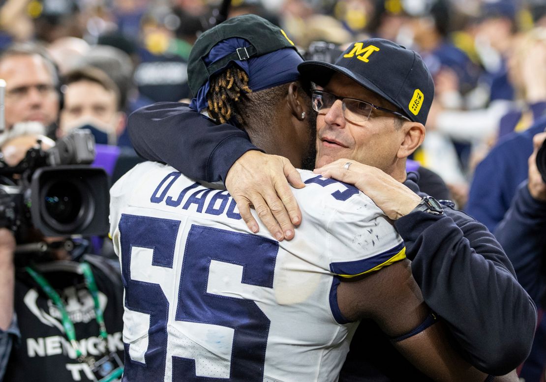 Ojabo and Michigan head coach Jim Harbaugh embrace after a game against the Iowa Hawkeyes.