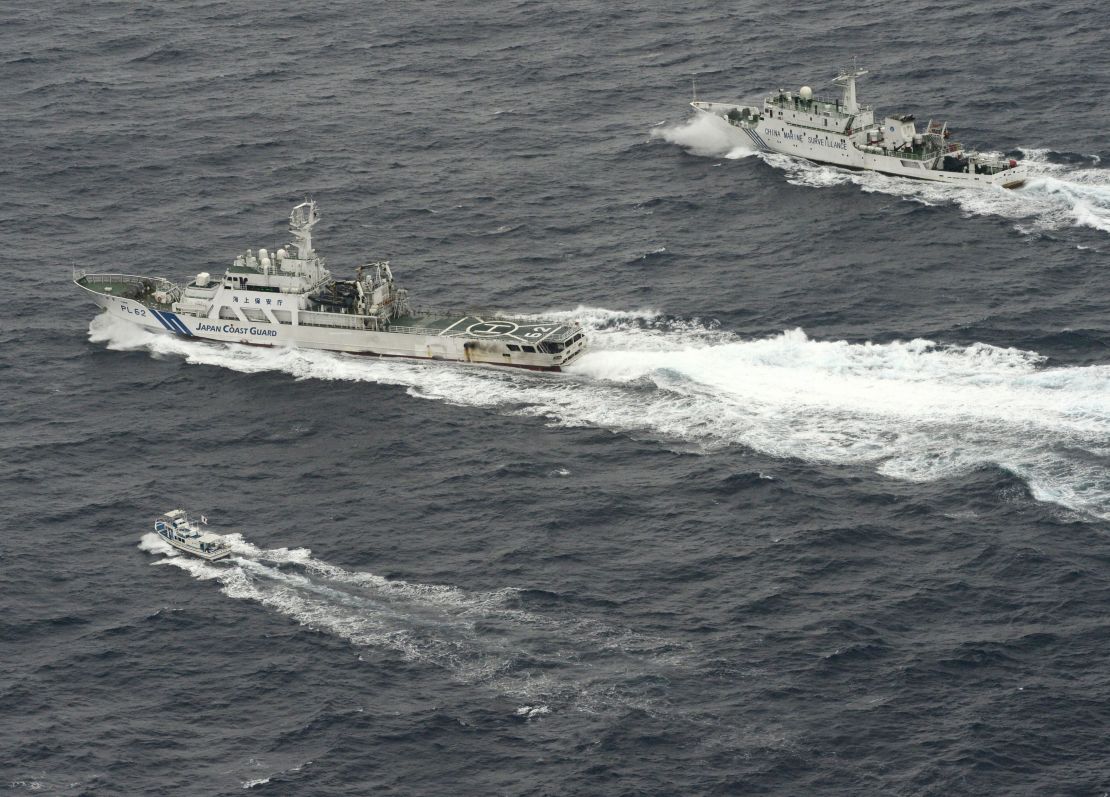 The Chinese marine surveillance ship, top, tries to approach a Japanese fishing boat, bottom, as a Japan Coast Guard vessel Ishigaki cruises next to the Chinese ship near what are known as the Senkaku isles in Japan and the Diaoyu islands in China, In April 2013.