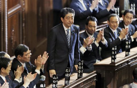 Abe stands up after being re-elected in 2014.
