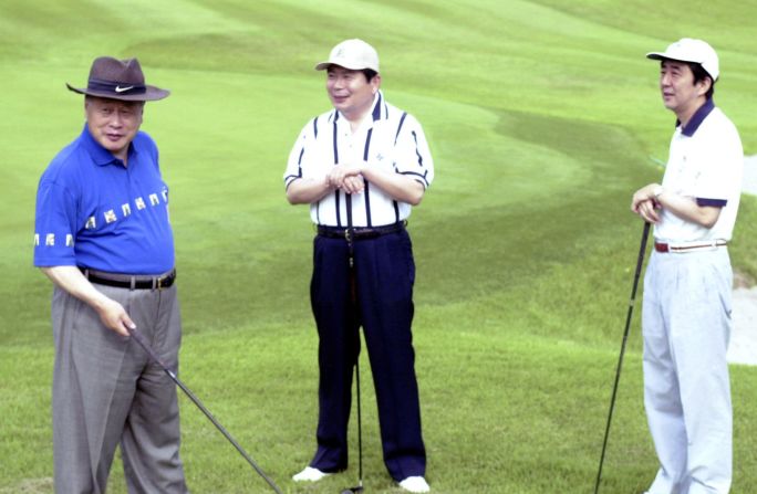 Abe, as deputy chief cabinet secretary, plays golf with Prime Minister Yoshiro Mori, left, and Chief Cabinet Secretary Hidenao Nakagawa, center, in 2000.