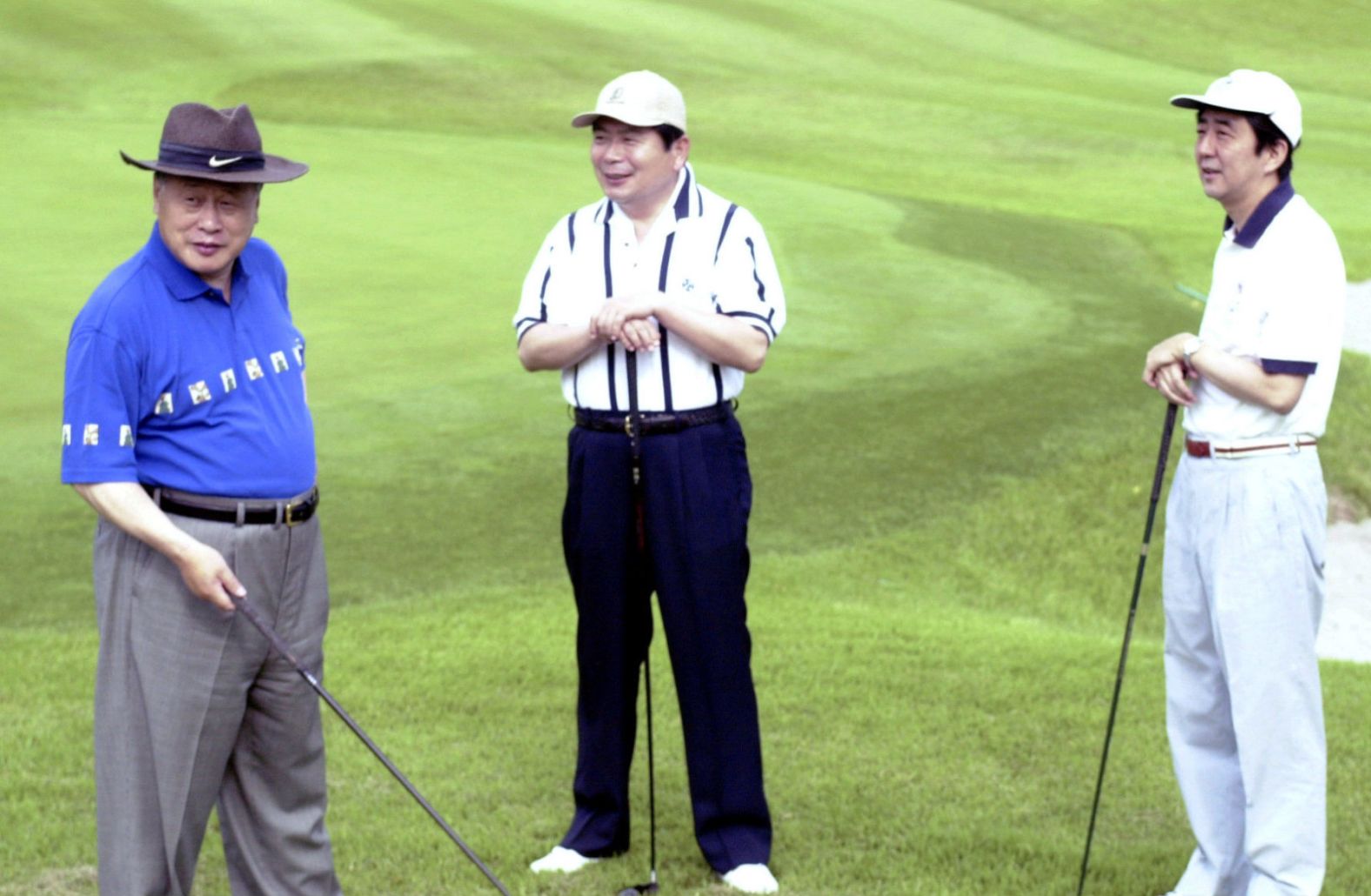 Abe, as deputy chief cabinet secretary, plays golf with Prime Minister Yoshiro Mori, left, and Chief Cabinet Secretary Hidenao Nakagawa, center, in 2000.