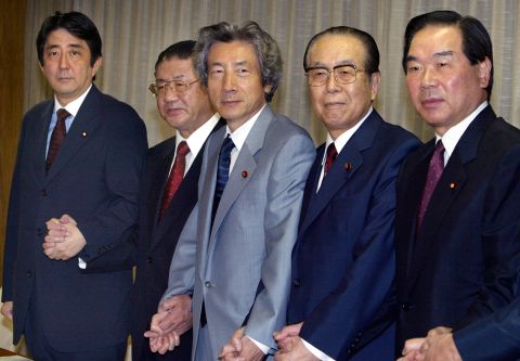 Abe, far left, stands with Japanese Prime Minister Junichiro Koizumi, center, and other members of the general council of the Liberal Democratic Party in 2003. Koizumi had just won re-election as president of the ruling party and had filled several key party positions.