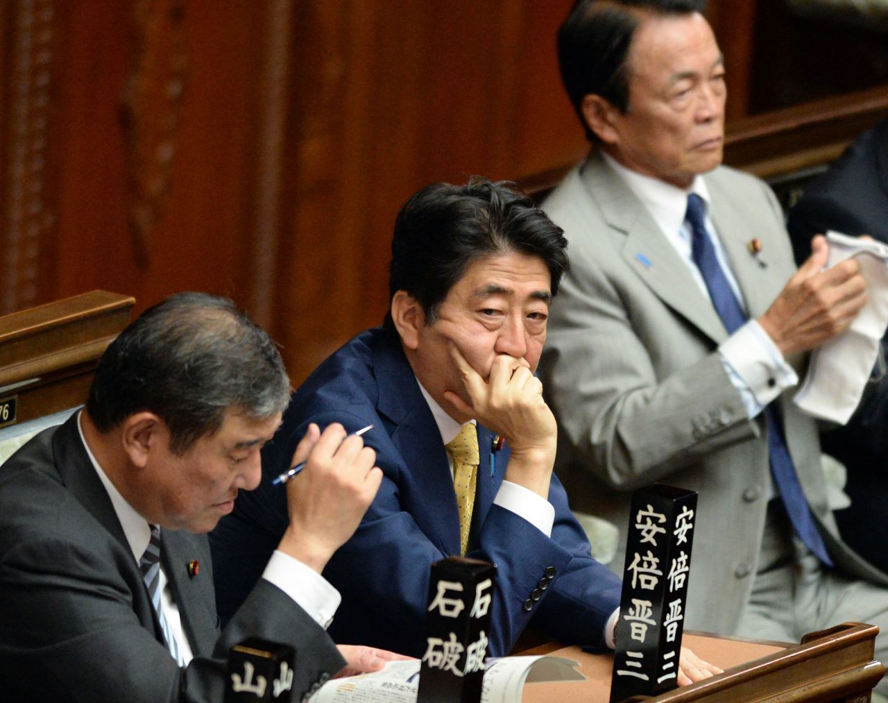 Abe listens to opposition lawmakers statements in Tokyo in 2015. Japan's ruling coalition rammed through a series of controversial security bills, marking the most significant overturn of the nation's "purely defensive" defense posture.