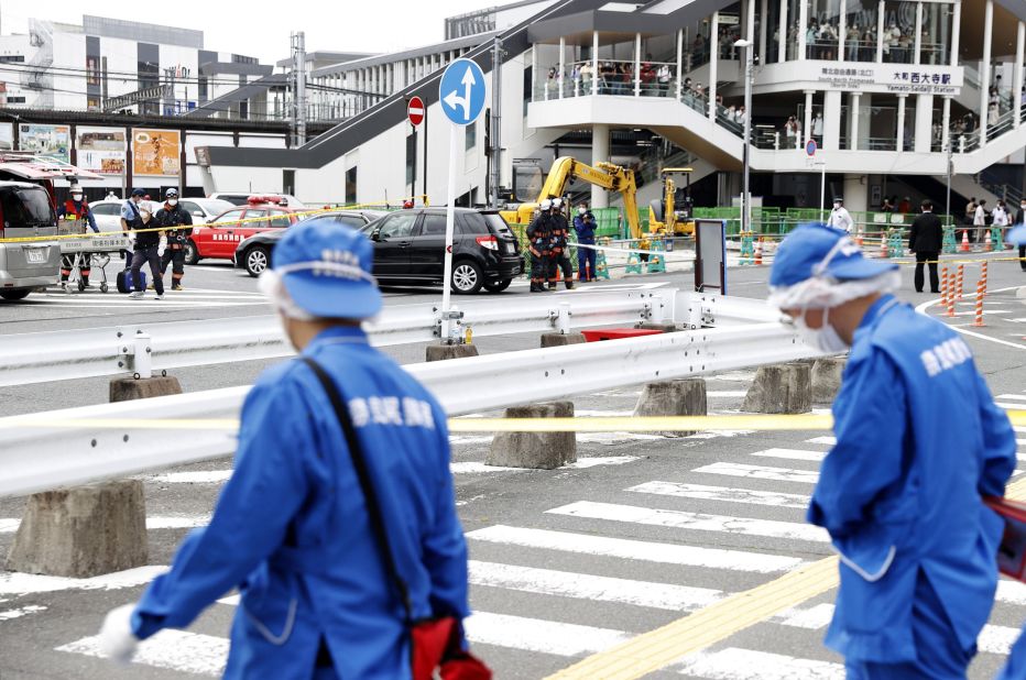 People walk near the location in Nara where Abe was shot on Friday.