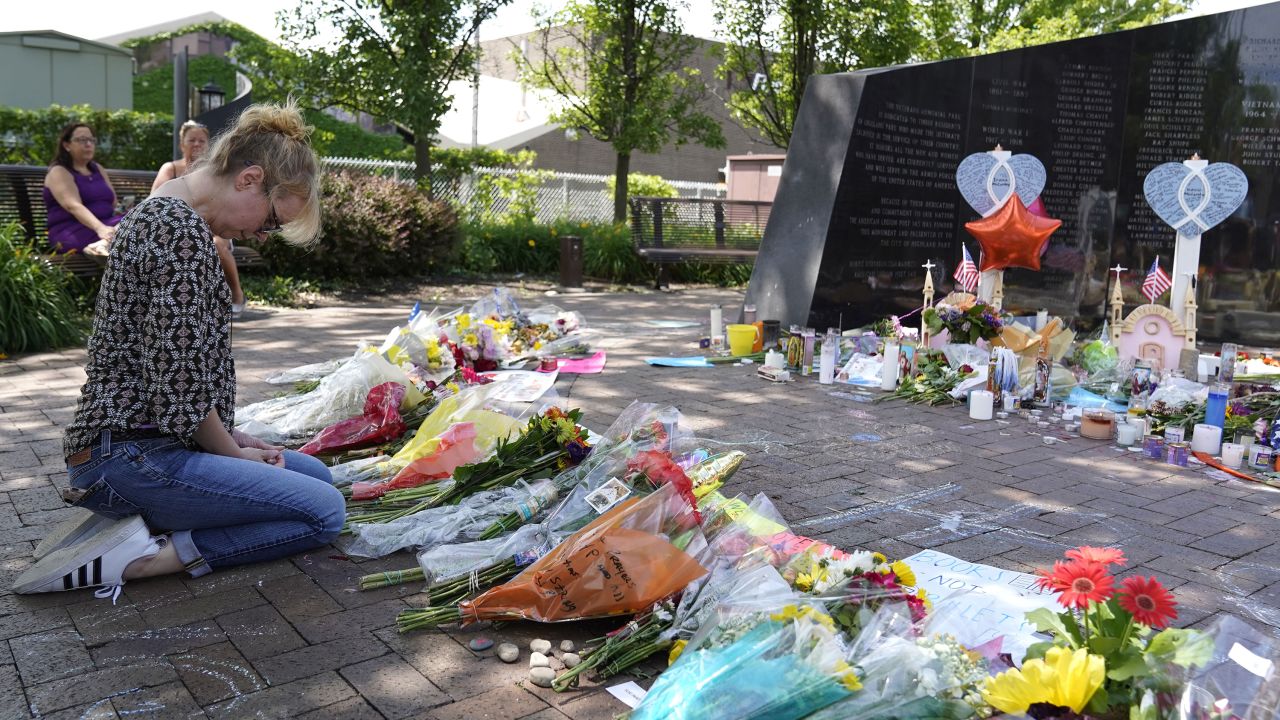 A visitor prays at a memorial to the seven people killed and others injured in Monday's Fourth of July mass shooting in Highland Park, Illinois.