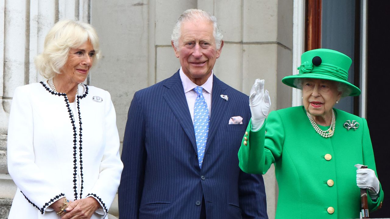 The Queen waves to crowds during the Platinum Jubilee finale, as Charles and Camilla stand nearby. 