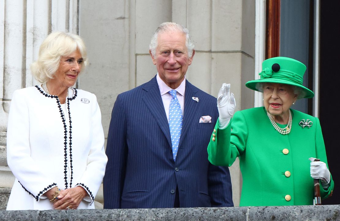 The Queen waves to crowds during the Platinum Jubilee finale, as Charles and Camilla stand nearby. 