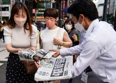 Extra edition newspapers about Japan's former Prime Minister Shinzo Abe being shot while campaigning in Nara, Japan, are being distributed to people on a street on July 8, in Tokyo.