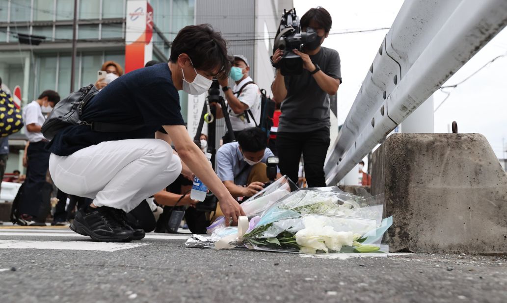 A man lays flowers at the site where Abe was shot on Friday.