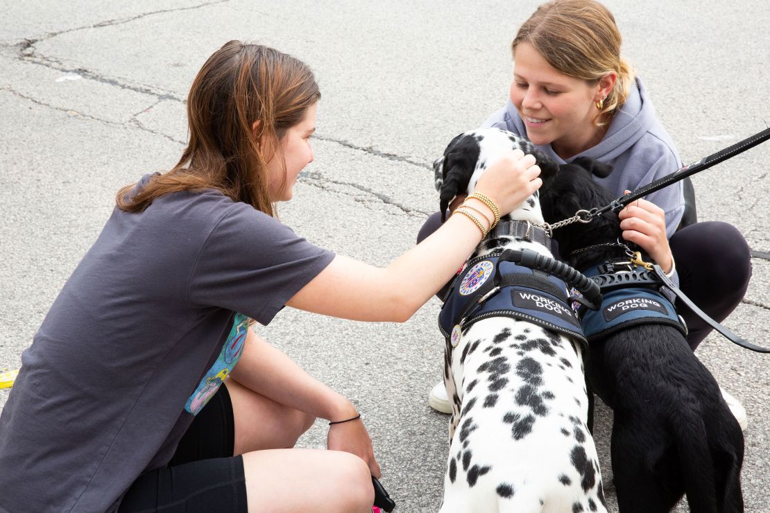 Eve Melnick and Marli Oleff pet crisis response dogs Kona and Lilo in Highland Park on July 6.