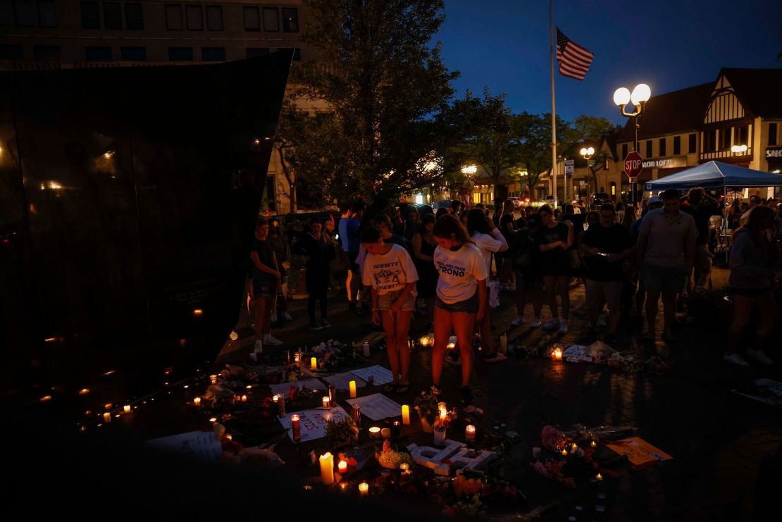 People leave signs and flowers at a memorial in Highland Park on July 5.