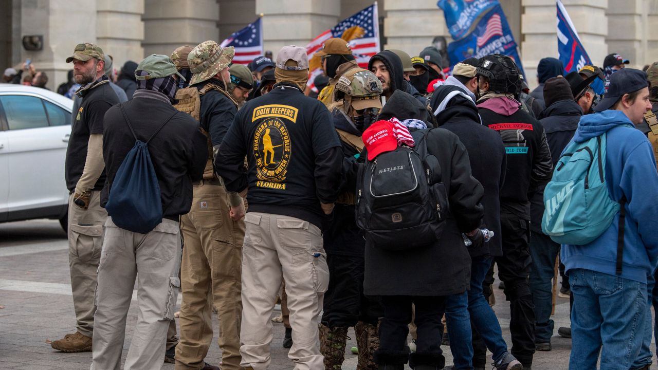  A group of men, some of whom are wearing "Oath Keepers" insignia, gathers as rioters storm the US Capitol in Washington on January 6, 2021.