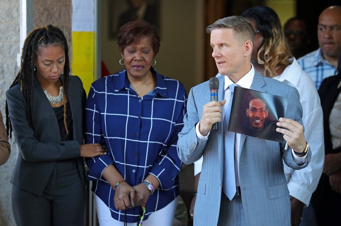 Attorney Bobby DiCello, right, holds up a photograph of Jayland Walker as attorney Paige White, left, comforts Walker's mother Pamela Walker during a June 30 news conference at St. Ashworth Temple in Akron.