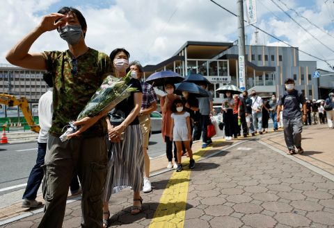 People queue up to offer flowers and pray at the site where late former Japanese prime minister Shinzo Abe was shot.