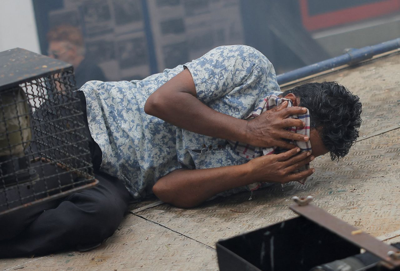 A protester reacts to tear gas that was used by police near the President's House on Saturday.